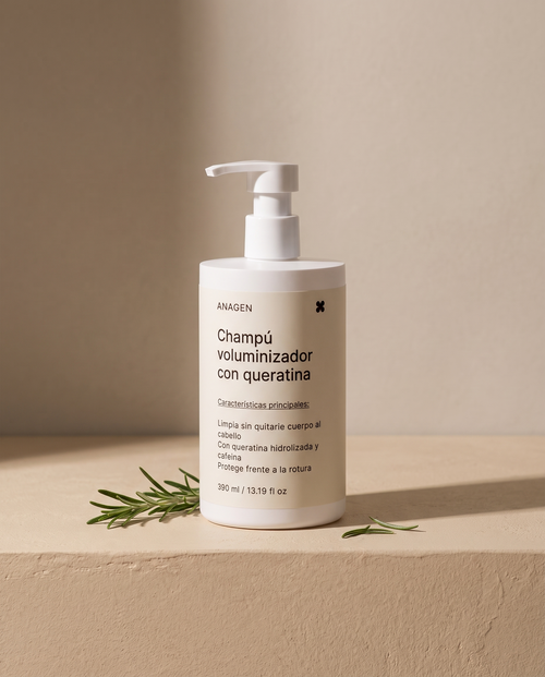 Champú Voluminizador con Queratina de Anagen sobre superficie de yeso beige con ramitas de romero